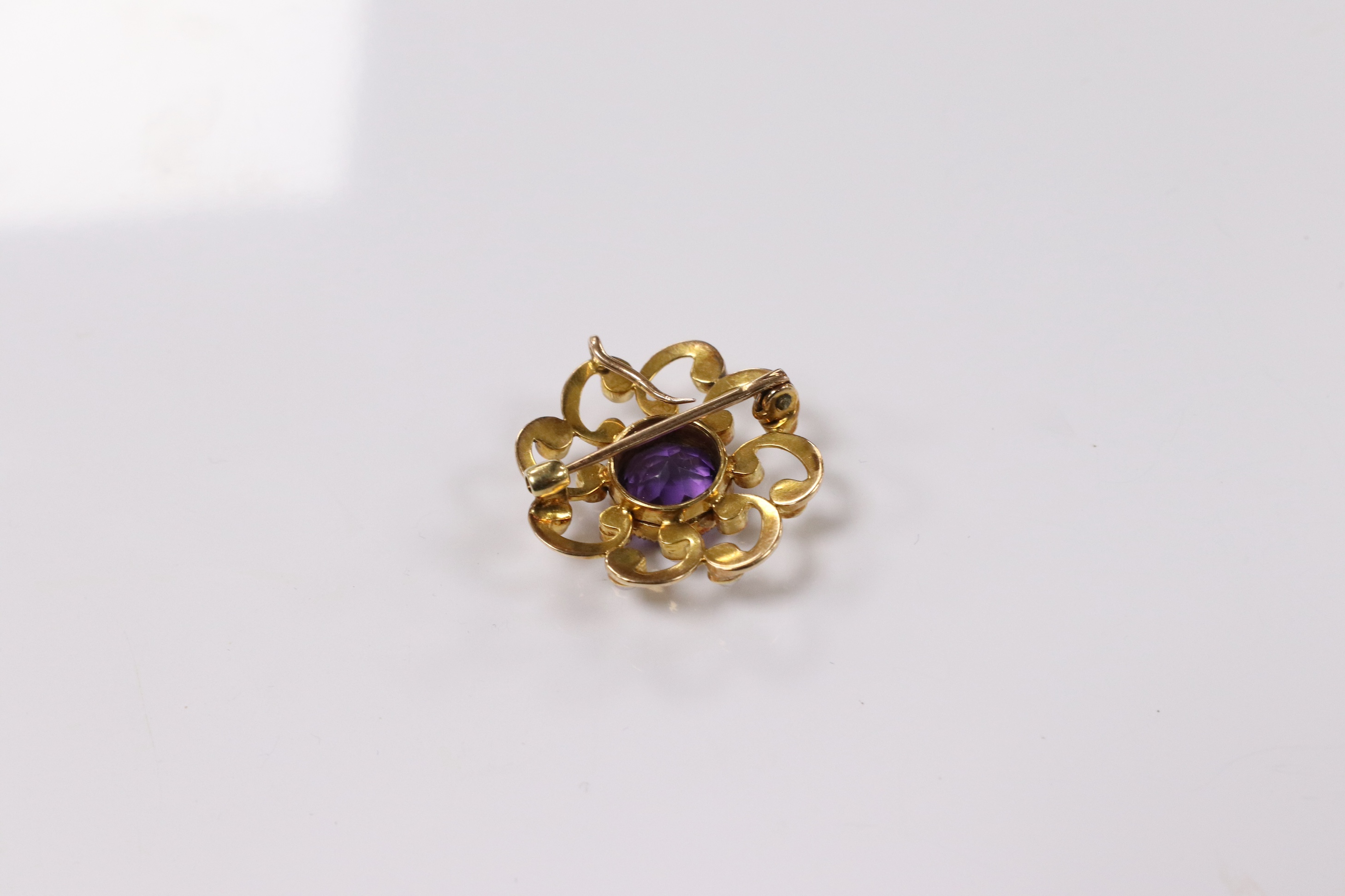 A yellow metal, amethyst and seed pearl cluster set circular pendant brooch, 24mm, gross weight 6.3 grams. Condition - fair to good